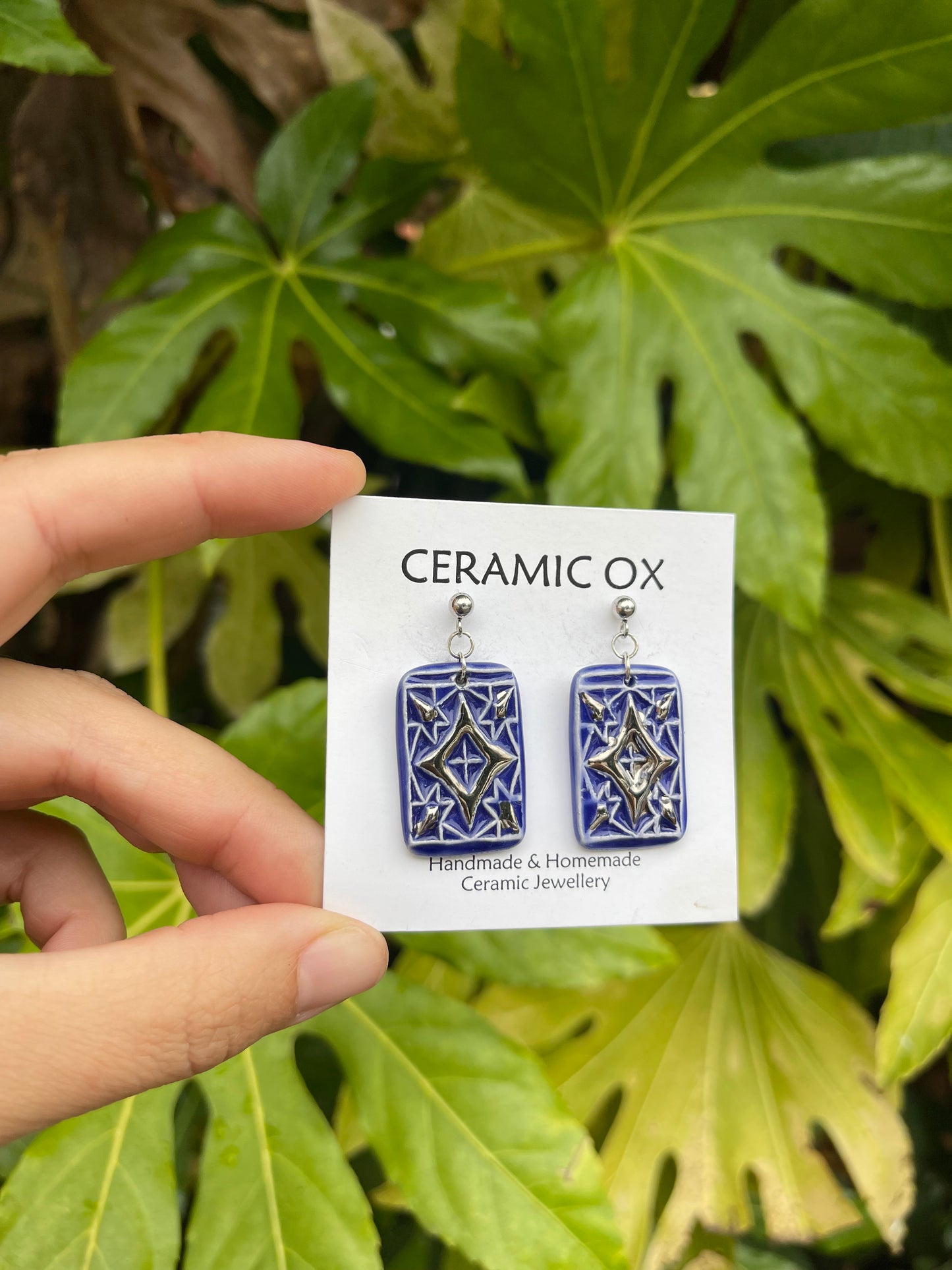 Blue dangly drop earrings with geometric silver detailing