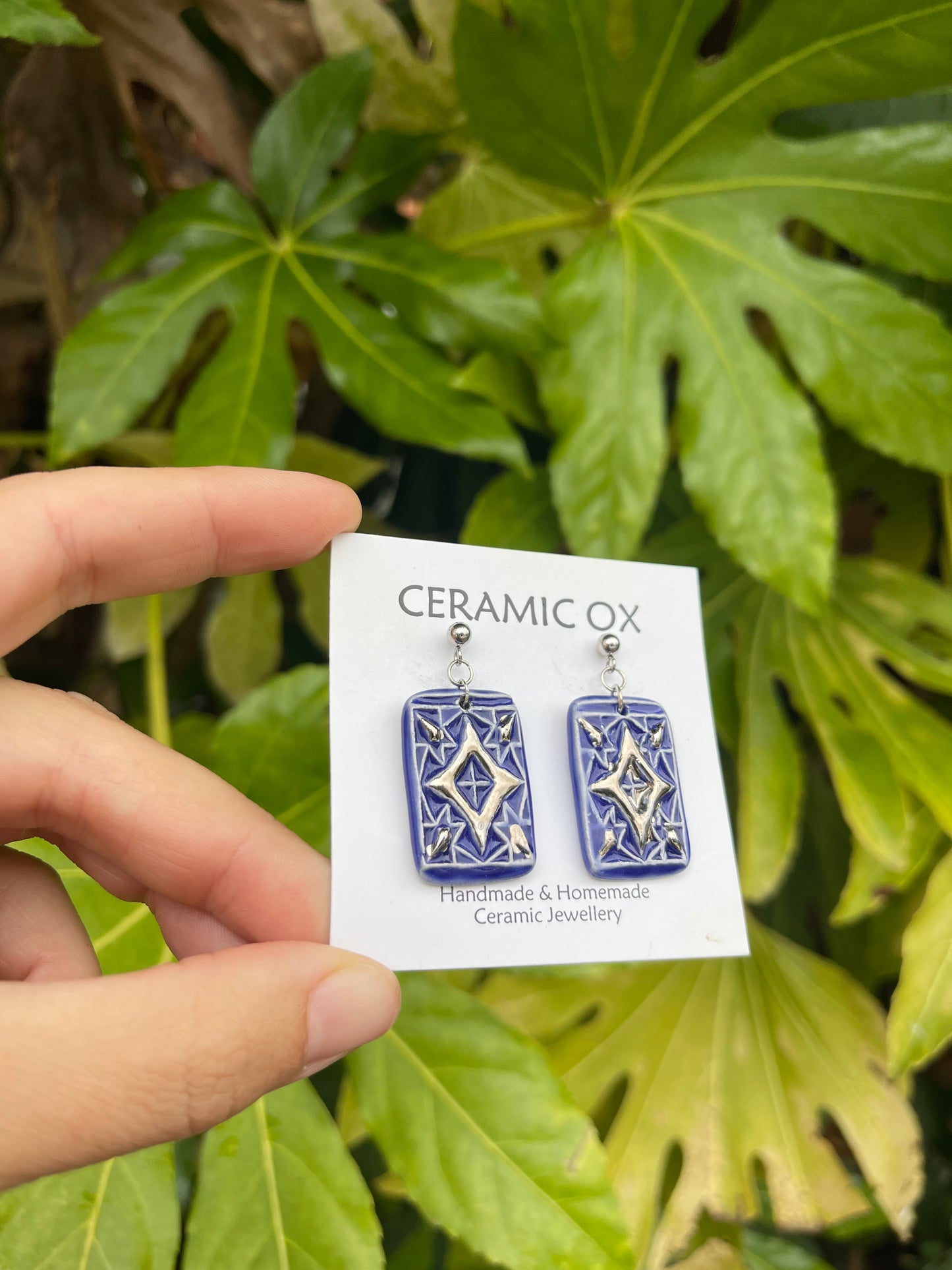 Blue dangly drop earrings with geometric silver detailing