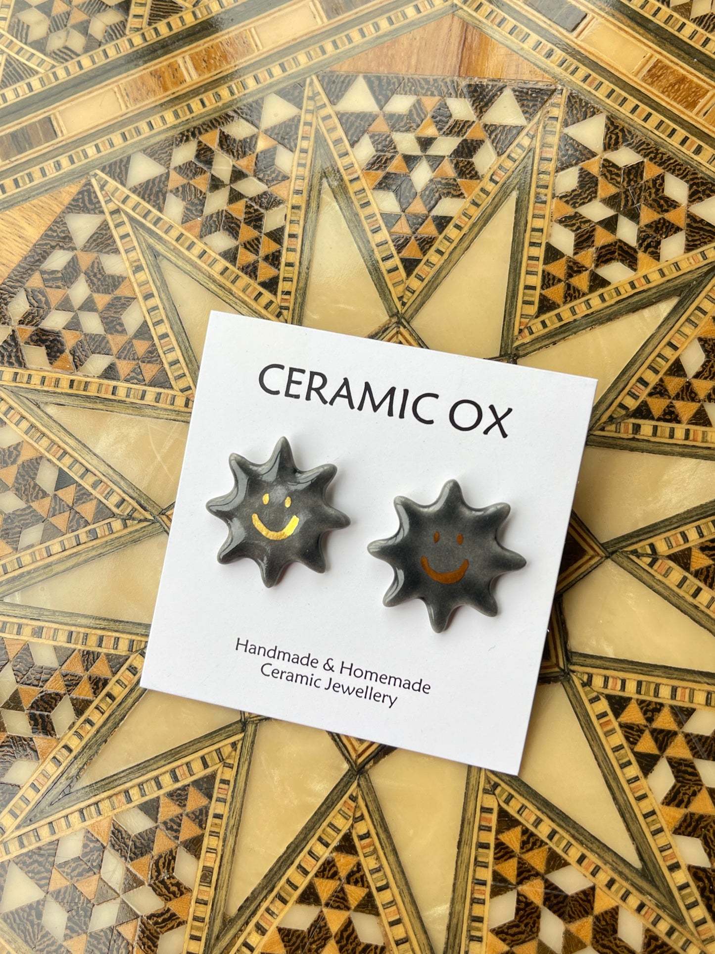 Smiley black sun studs
