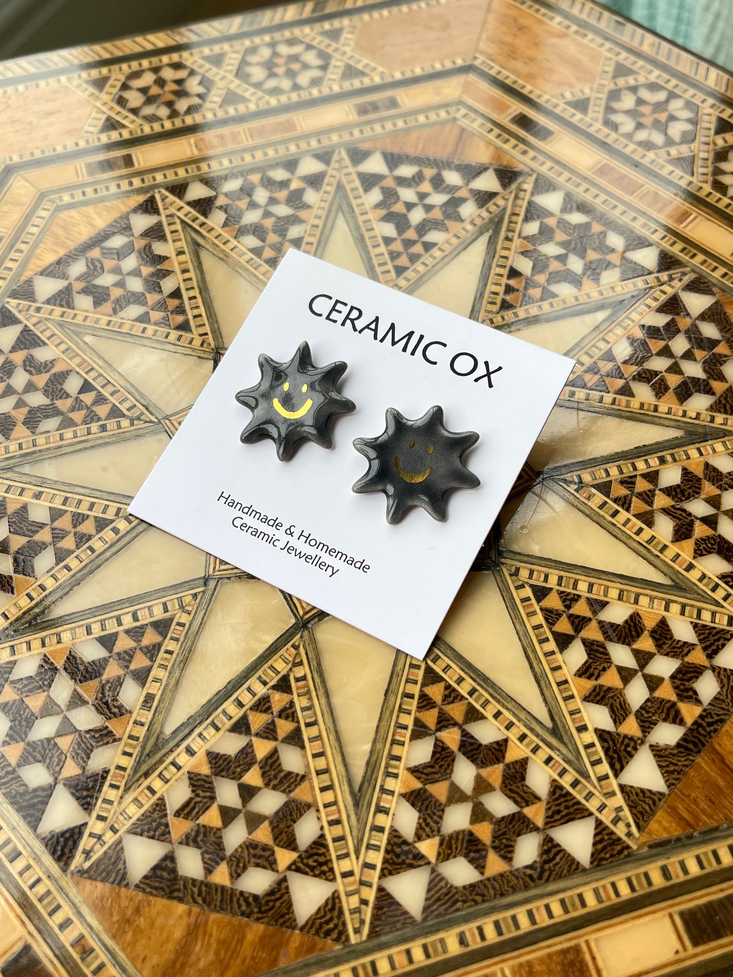 Smiley black sun studs