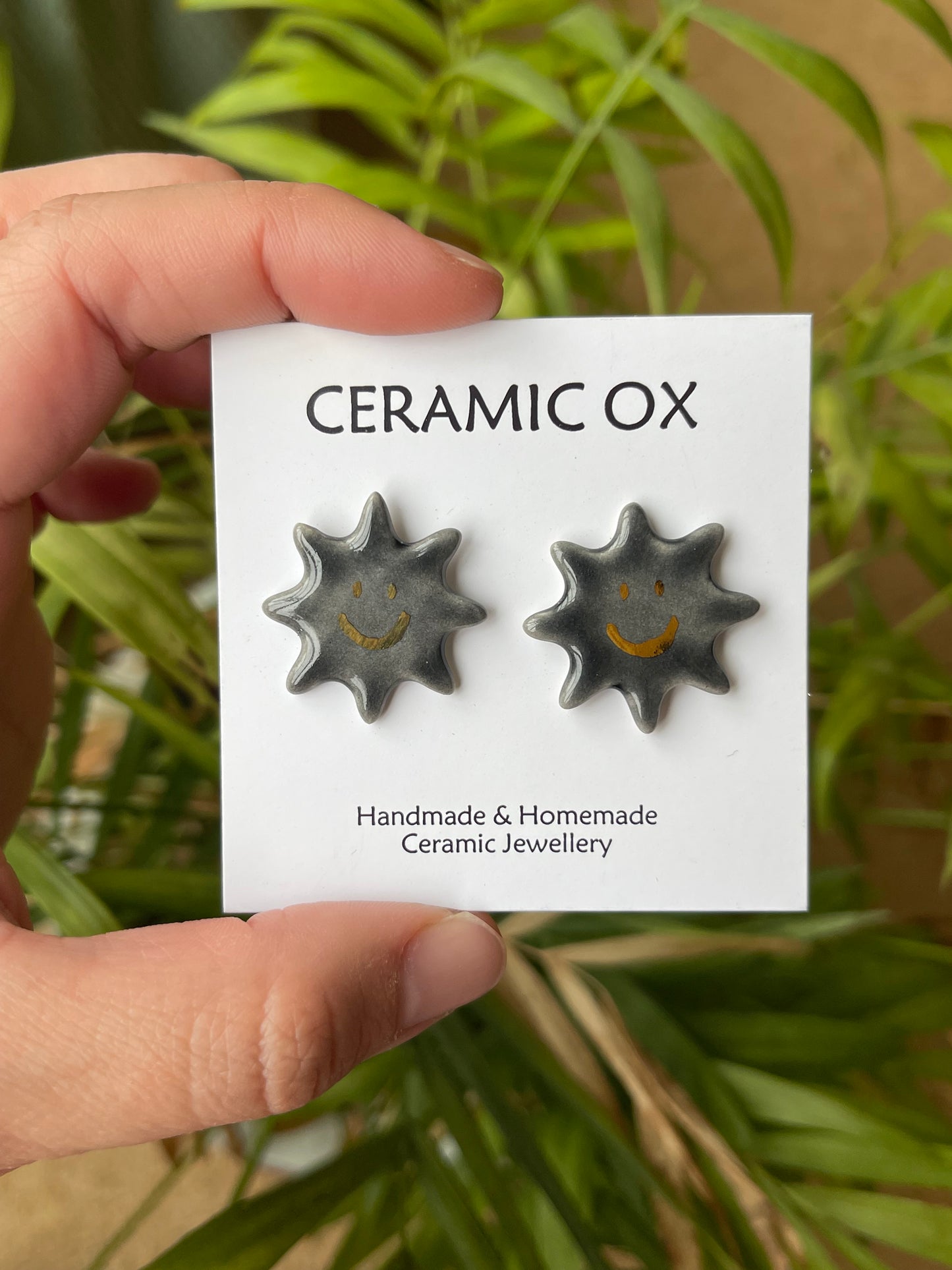 Smiley black sun studs