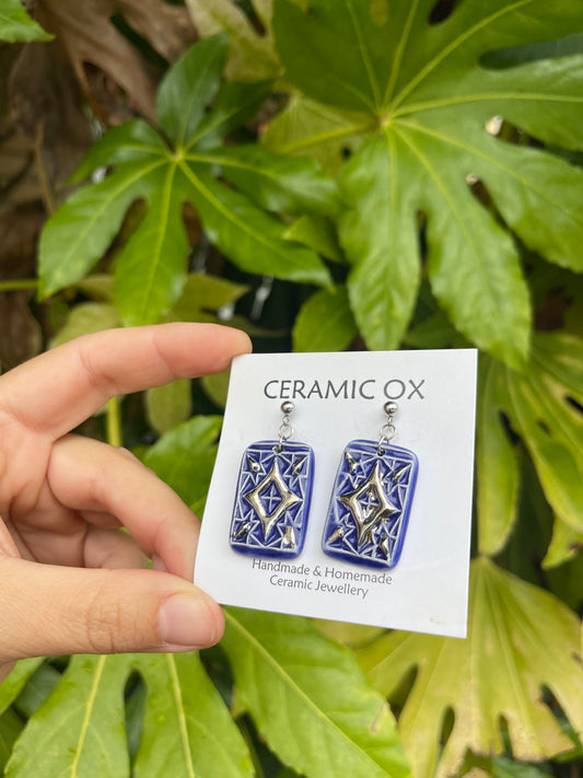 Blue dangly drop earrings with geometric silver detailing