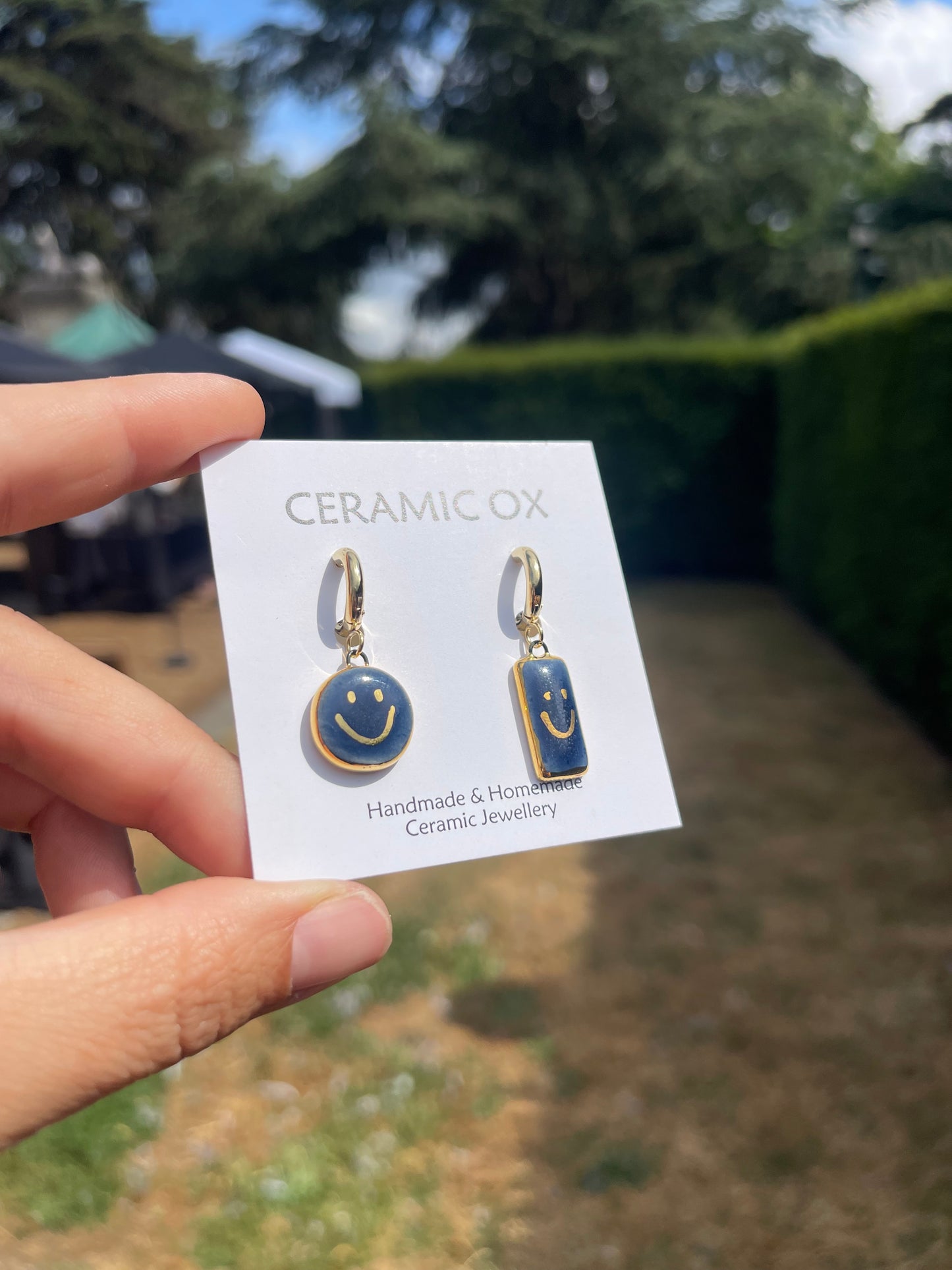 Navy asymmetric smiley face hoops