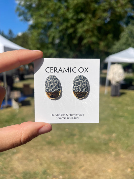 Grey/black textured convex oval gold dipped studs